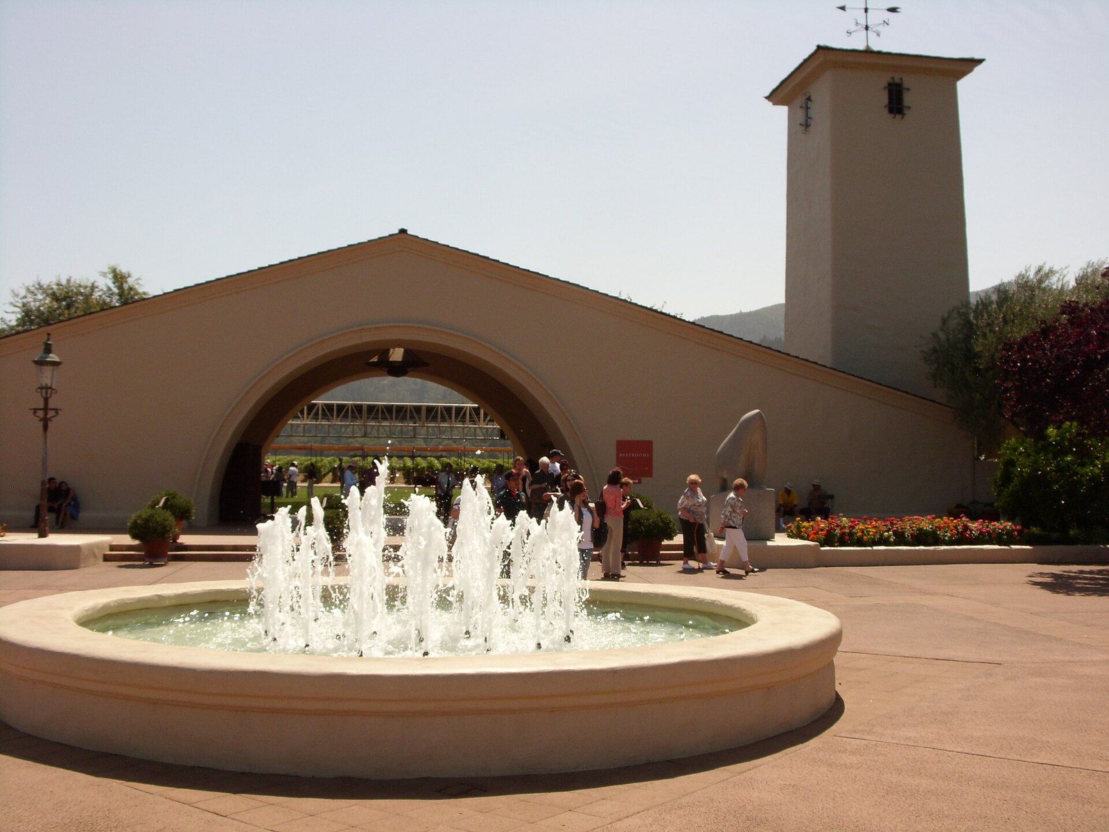 The arched entry and bell tower of the Robert Mondavi Winery in Oakville, behind a fountai, a Wikimedia Commons photograph in the encyclopedia of Mike Kobeissi