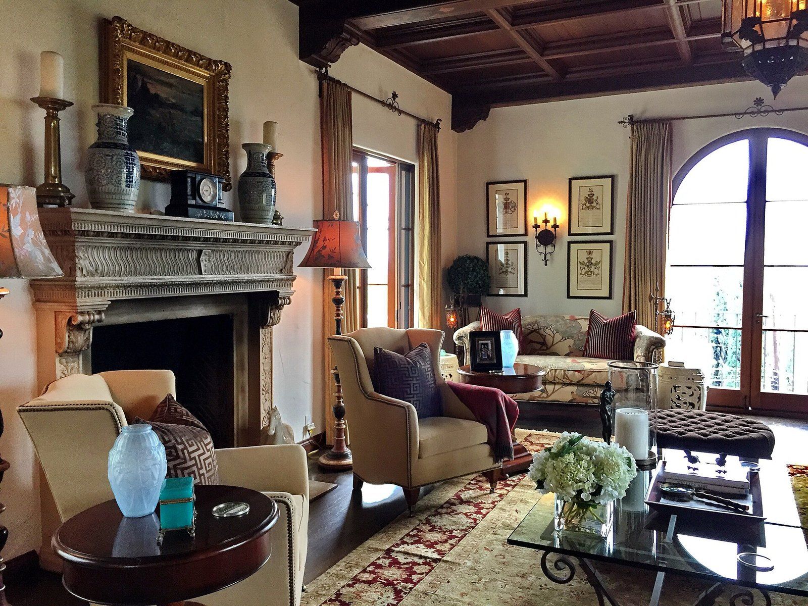 A Spanish style living room with a carved stone fireplace, beamed ceiling and arched windo, a Wikimedia Commons photograph in the encyclopedia of Mike Kobeissi