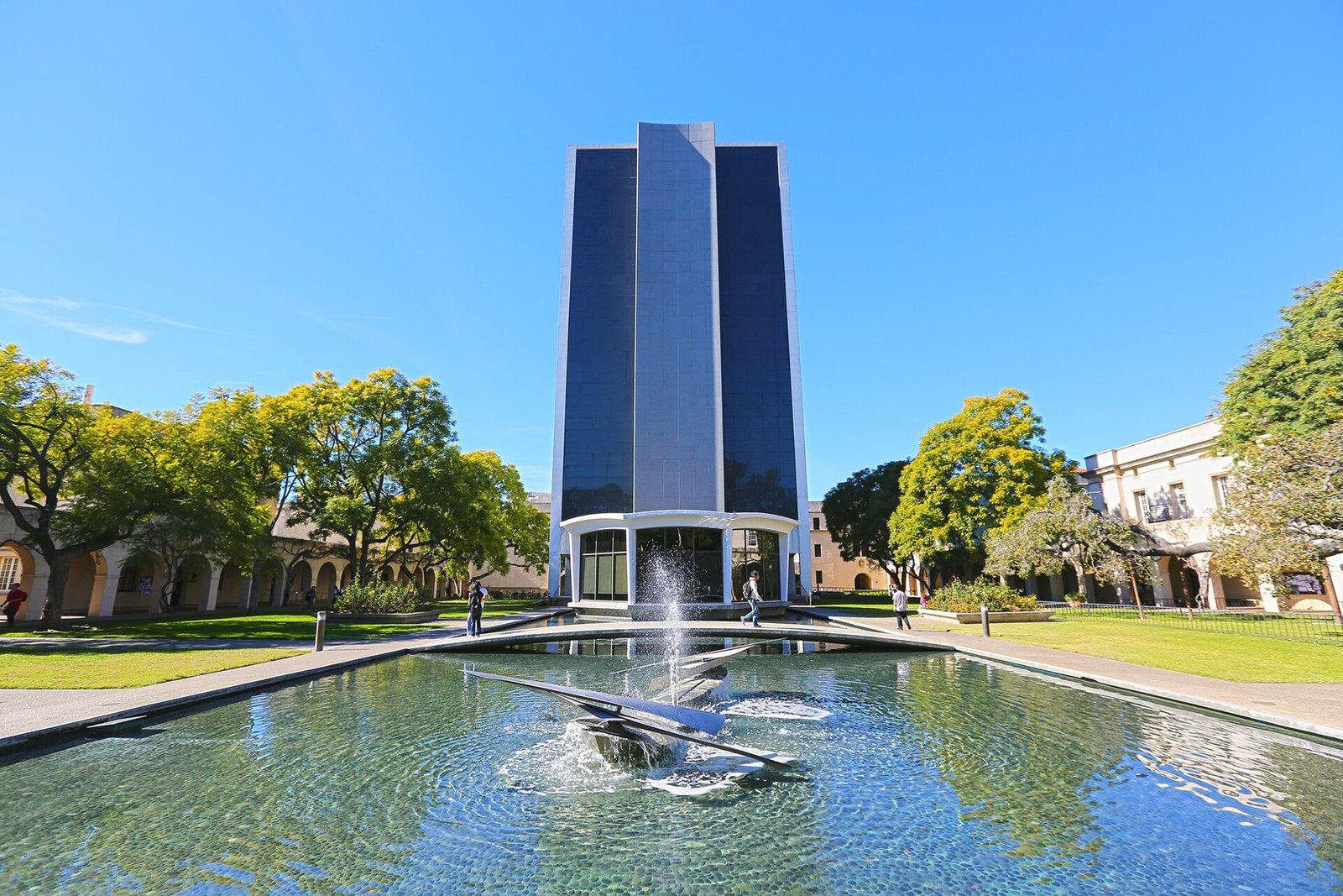 The Millikan Library tower rising beyond a reflecting pool on the Caltech campus in Pasade, a Wikimedia Commons photograph in the encyclopedia of Mike Kobeissi