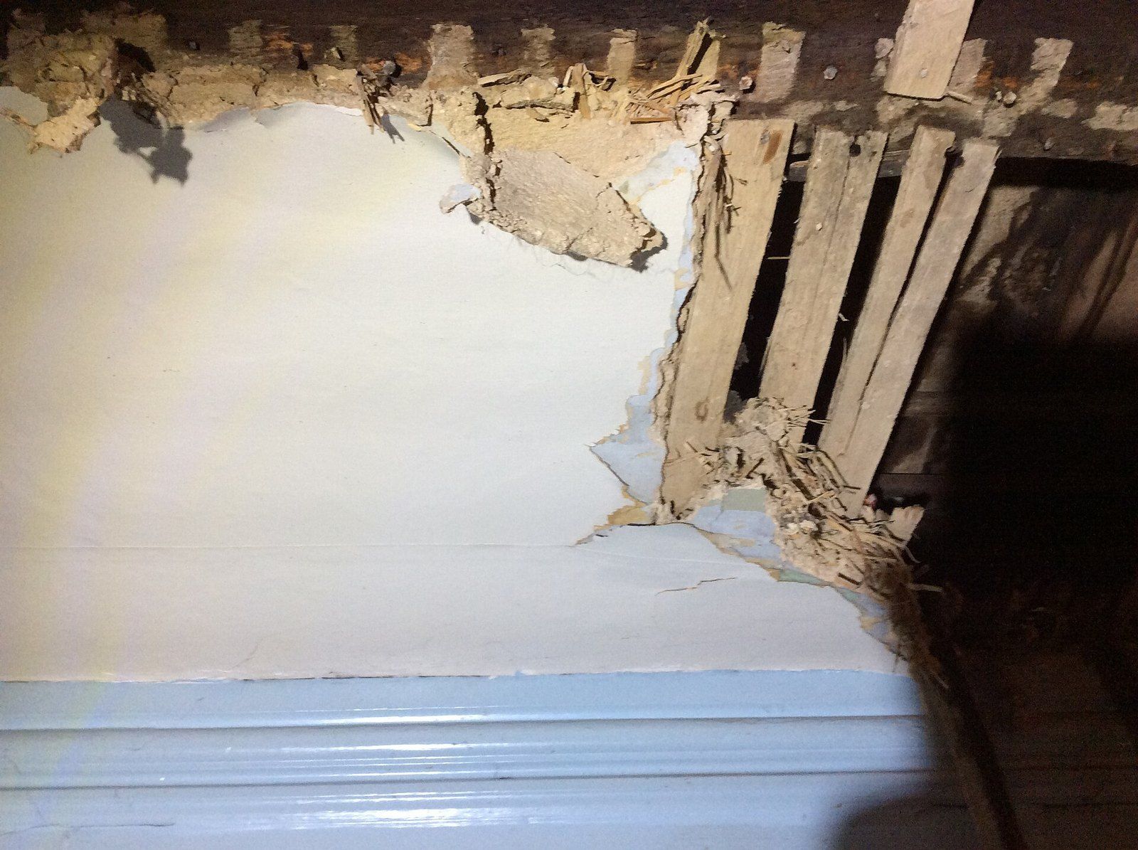 A broken clay plaster ceiling showing the strips of wood lath behind it, a Wikimedia Commons photograph in the encyclopedia of Mike Kobeissi