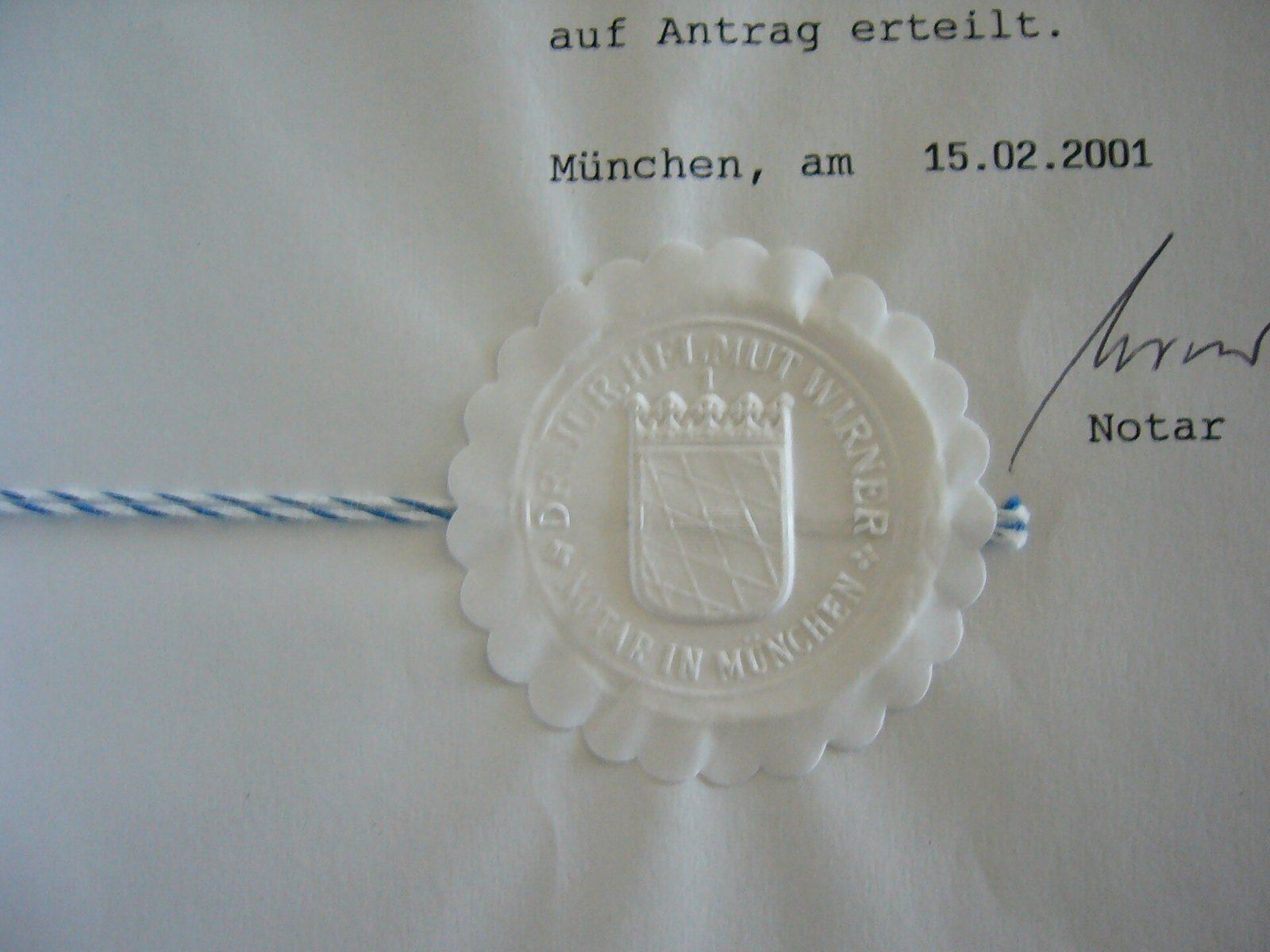 An embossed notary seal pressed into a signed document with a cord, a Wikimedia Commons photograph in the encyclopedia of Mike Kobeissi