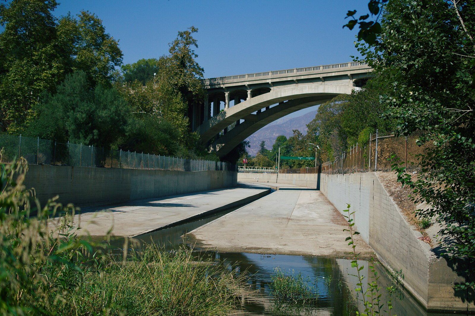 The concrete channel of the Arroyo Seco in Pasadena, with an arched bridge beyond, a Wikimedia Commons photograph in the encyclopedia of Mike Kobeissi