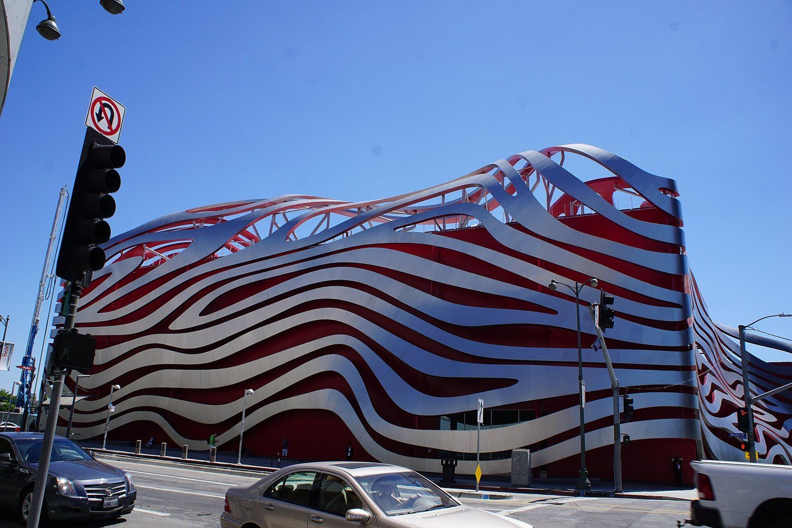 The red and steel ribbon facade of the Petersen Automotive Museum on Wilshire Boulevard, a Wikimedia Commons photograph in the encyclopedia of Mike Kobeissi