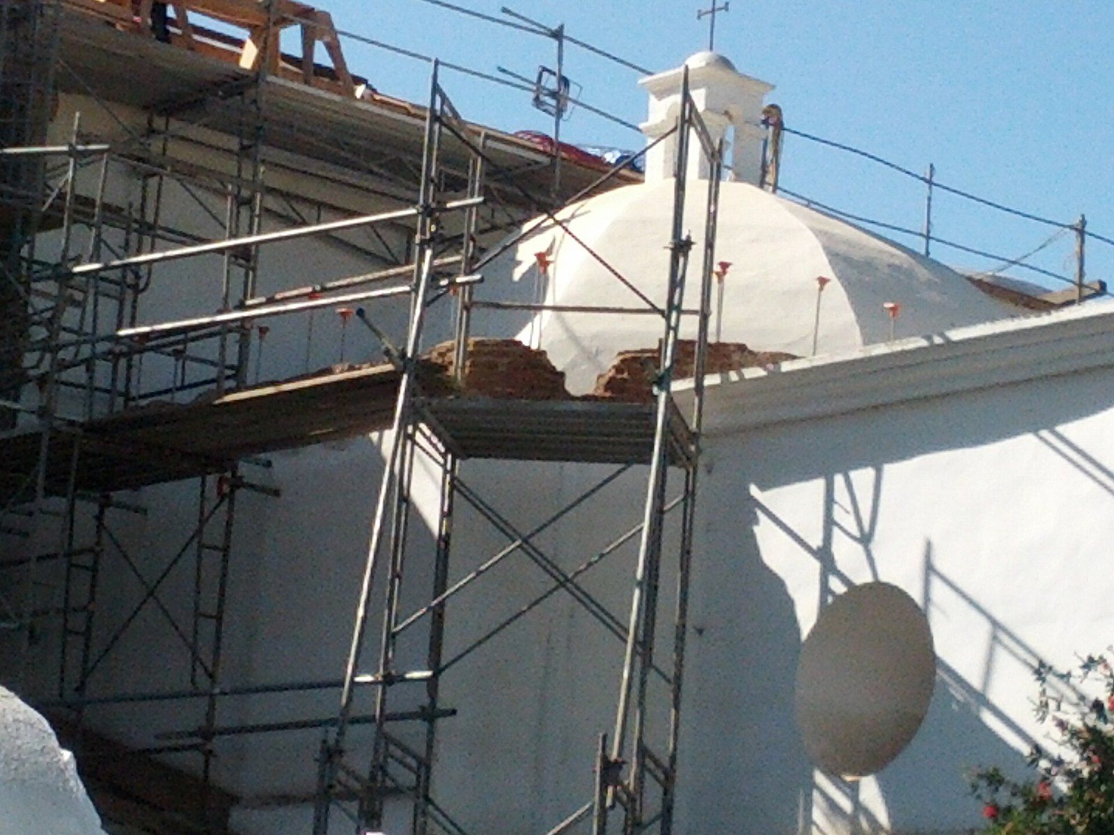 The white bell tower and dome of Mission San Luis Rey church wrapped in scaffolding during, a Wikimedia Commons photograph in the encyclopedia of Mike Kobeissi