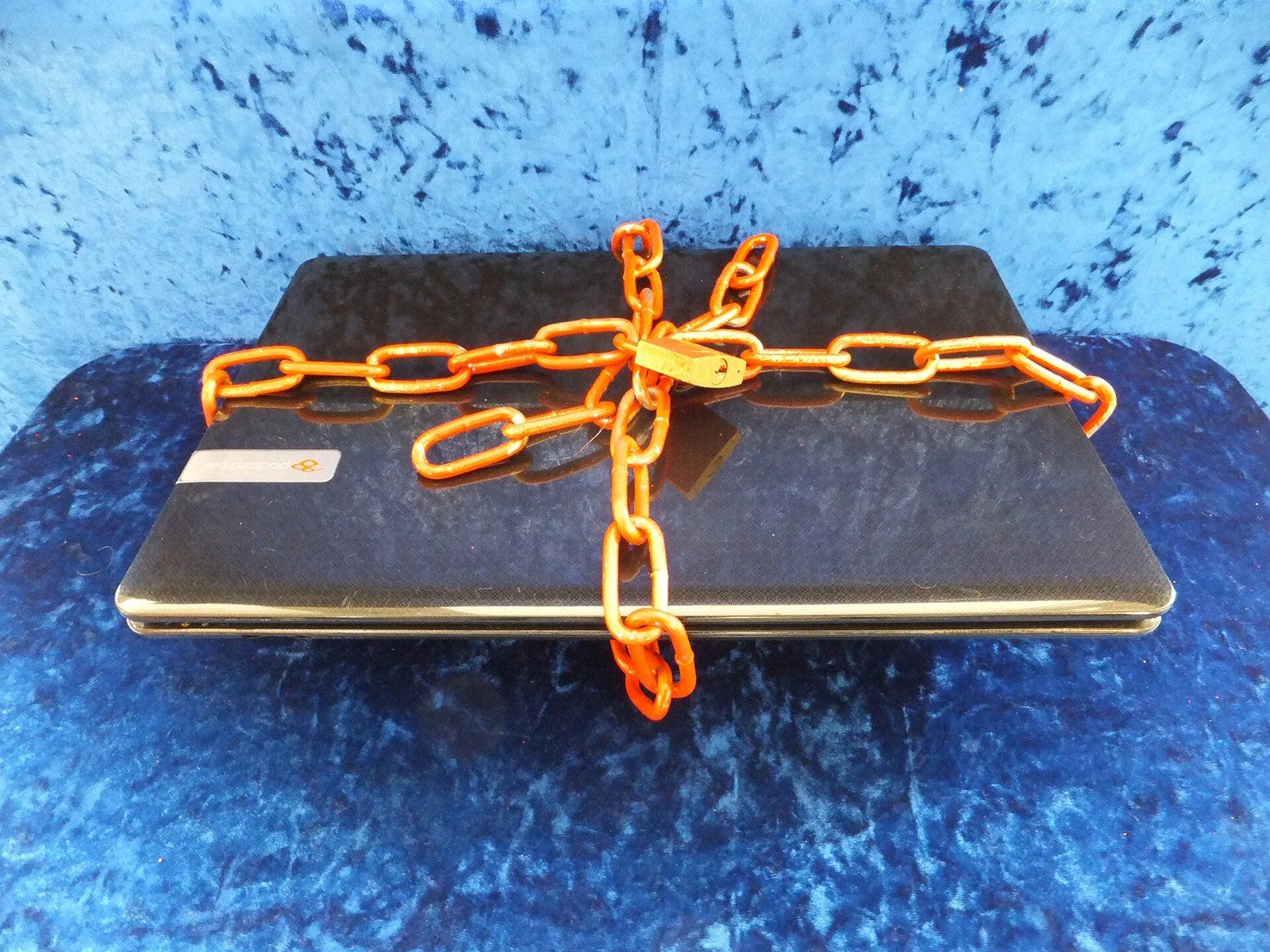 A closed laptop wrapped in a chain, a picture of locked down computing, a Wikimedia Commons photograph in the encyclopedia of Mike Kobeissi